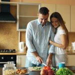 Happy young couple in the kitchen. Handsome man meet his girlfriend early morning at home