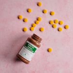 a bottle of medicine with the cap off next to pills