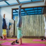 woman in white tank top and pink leggings doing yoga